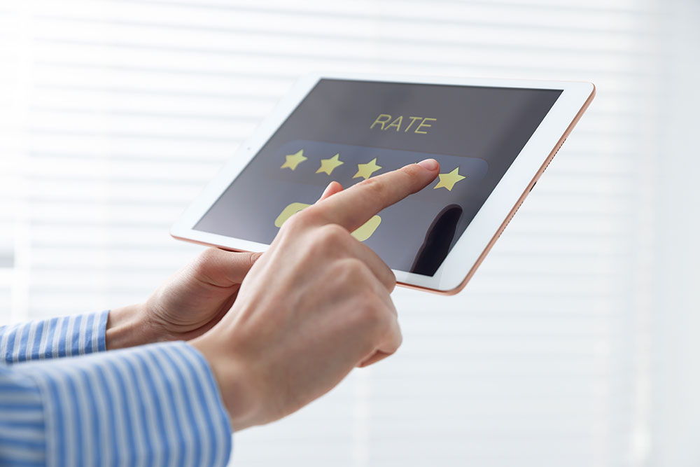 close up of hands giving a five star rating on a tablet